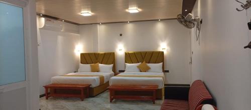 een hotelkamer met twee bedden en een bank bij Best View Guest Inn Ella in Ella