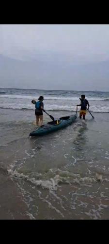 two people are standing on the beach with a kayak at Beach Bungalow 100 m Playa Coson in Las Terrenas