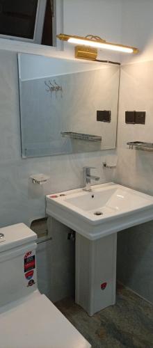 a white bathroom with a sink and a toilet at Best View Guest Inn Ella in Ella