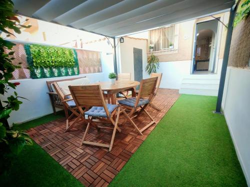 a table and chairs on a patio with grass at Costamar playa arenales del sol in Arenales del Sol