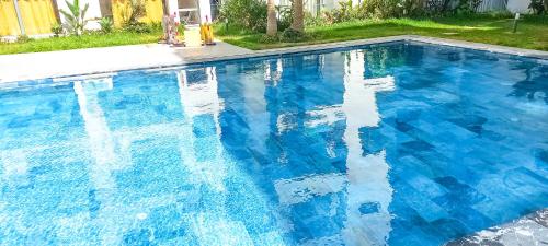 a large blue swimming pool with blue water at Affordable Luxury Apartment in Nouaseur