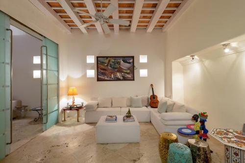 a living room with a white couch and a table at Heated pool Spectacular House Historic Center in Cartagena de Indias
