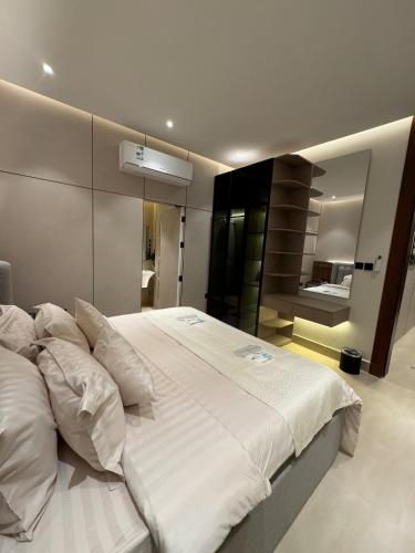 a large white bed in a bedroom with a mirror at Luxurious suite with a terrace overlooking KAFD in Riyadh