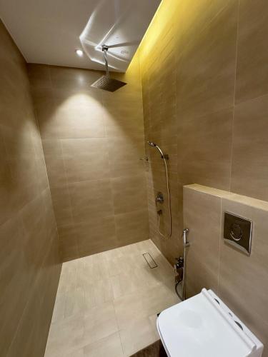 a bathroom with a shower and a toilet in it at Luxurious suite with a terrace overlooking KAFD in Riyadh