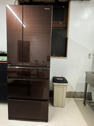 a kitchen with a refrigerator and a trash can at FujiBaseGotemba Sta 3-mins walk in Gotemba