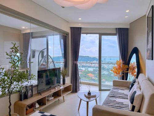 a living room with a couch and a large window at PƠ Homestay THESONG Vũng Tàu in Vung Tau