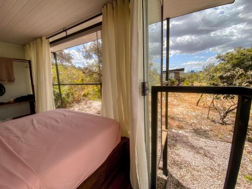 a bedroom with a bed and a window with a view at Casa Borba Chalé panorâmico in Alto Paraíso de Goiás