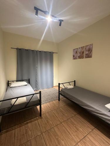 two beds in a room with a ceiling fan at Pousada Araquari in Paraty