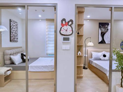 a room with two beds and a clock on the wall at PƠ Homestay THESONG Vũng Tàu in Vung Tau