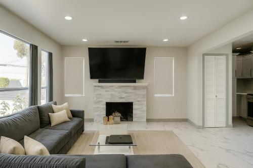 a living room with a couch and a fireplace at The Pacific Nest - 10min from LAX in Hawthorne