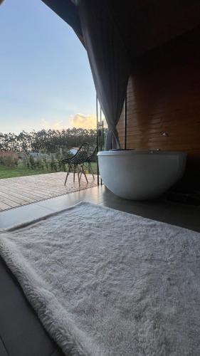 a living room with a large window and a rug at Chalé Tiny house com banheira e lareira in Osório
