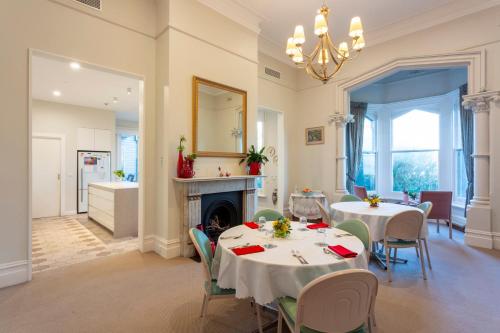 a dining room with two tables and a fireplace at Mary MacKillop Spirituality Centre, St Joseph's by the sea in Williamstown