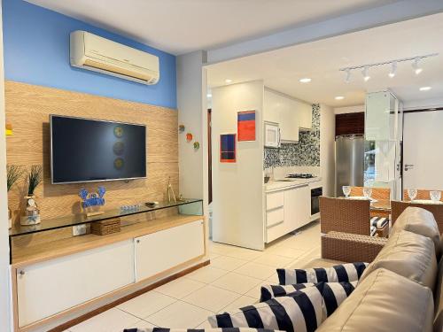 ein Wohnzimmer mit Couch und Flachbildfernseher in der Unterkunft Nannai Residence Muro Alto Porto Galinhas BeiraMar in Porto De Galinhas