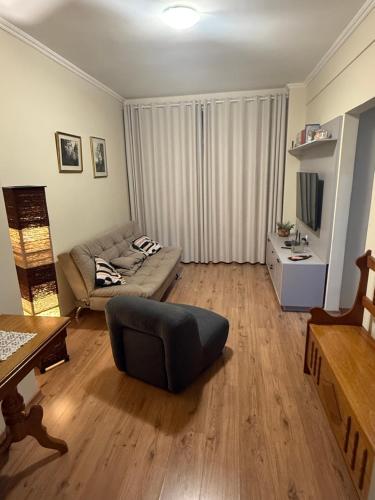 a living room with a couch and a table at Edificio na rua do Parque das Aguas in São Lourenço