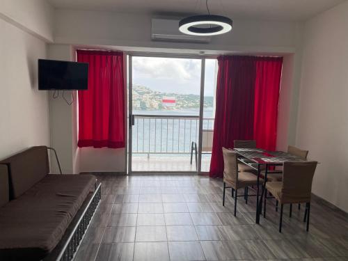 a living room with a table and red curtains at Hermosa Suite Torres Gemelas in Acapulco