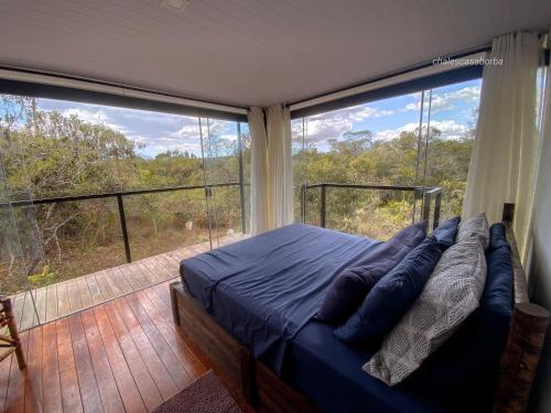 a bedroom with a bed and a large window at Casa Borba Chalé encantador in Alto Paraíso de Goiás