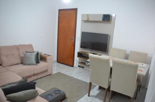 a living room with a couch and a television at Apto 2 dormitórios 1 banheiro 1 vaga descoberta in Piracicaba