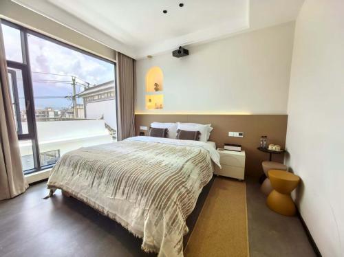 a bedroom with a large bed and a large window at Shiguang Wai · Manhai Yunshe Homestay in Dali Ancient Town