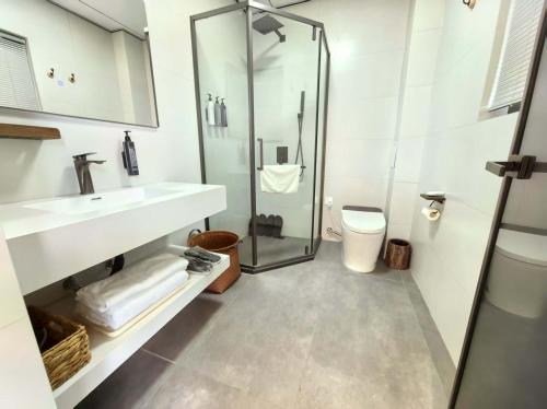 a bathroom with a shower and a sink and a toilet at Shiguang Wai · Manhai Yunshe Homestay in Dali Ancient Town