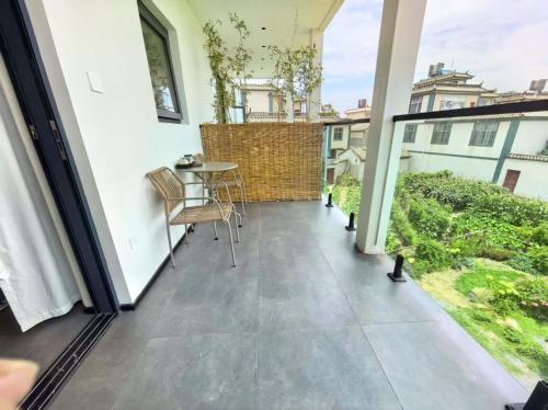 a patio with a table and chairs on a balcony at Shiguang Wai · Manhai Yunshe Homestay in Dali Ancient Town