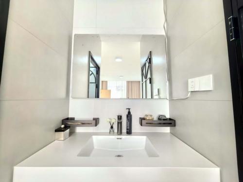 a white bathroom with a sink and a mirror at Shiguang Wai · Manhai Yunshe Homestay in Dali Ancient Town