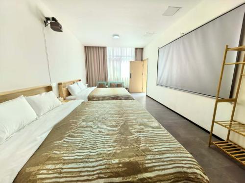 a room with three beds and a large screen at Shiguang Wai · Manhai Yunshe Homestay in Dali Ancient Town