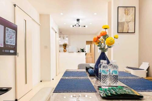 a living room with a table with a vase of flowers at Megumi in Osaka