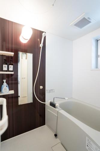 a bathroom with a sink and a bath tub at Maxim 2-B in Naha