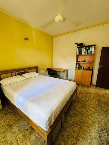 a bedroom with a large bed and a yellow wall at Lake Lodge 4 bed rooms spacious house with 3 Bath in Battaramulla