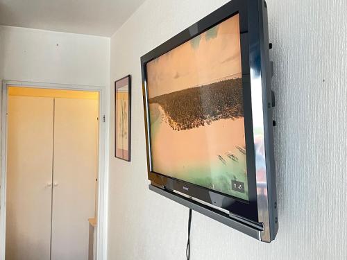 a flat screen tv hanging on a wall at - - - - - Au Sixième Ciel - - - - - in Brussels