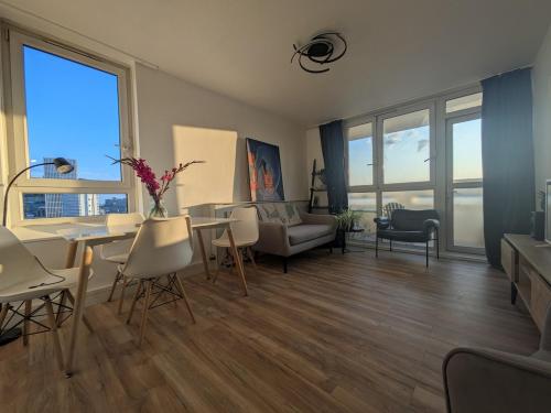 Stylish 1 Bedroom Flat in Old Street في لندن: غرفة معيشة كبيرة مع طاولة وكراسي