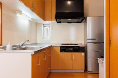 a kitchen with a sink and a refrigerator at 本部町Mio Styleは美ら海水族館まで10分の好立地の一棟貸BBQ可能 in Motobu
