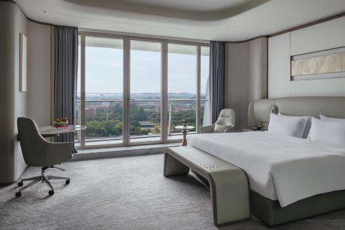 a hotel room with a bed and a large window at Vignette Collection The Xanadu Guangzhou, an IHG Hotel in Guangzhou
