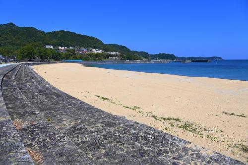 a sandy beach with the ocean in the background at Pals Inn Katsuura in Katsuura