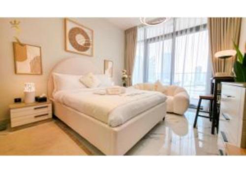 een slaapkamer met een wit bed en een stoel bij Modern Studio in Al Maryah Vista in Abu Dhabi