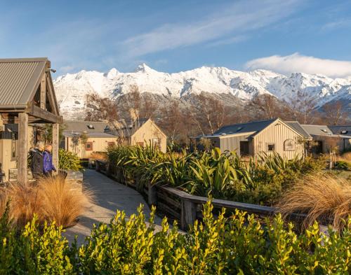 a village with snow covered mountains in the background at The Headwaters Eco Lodge in Glenorchy