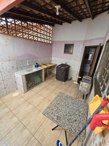 a kitchen with a sink and a table in a room at Casa aconchegante A , 4 minutos do thermas in Andradina