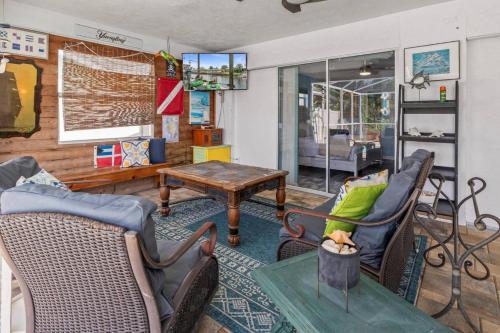アポロ・ビーチにあるPirates Den a 4BR Pet-Friendly Waterfront Oasis with Pool, Dock, Personal Water Boats, Fire Pit, Game Room and Barの椅子とテーブルのあるリビングルーム