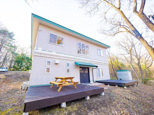 a house with a picnic table in front of it at venasuｵｰﾍﾞﾙｼﾞｰﾇ館 卓球カラオケ シアター 石風呂 ドッグラン BBQ in Nasushiobara