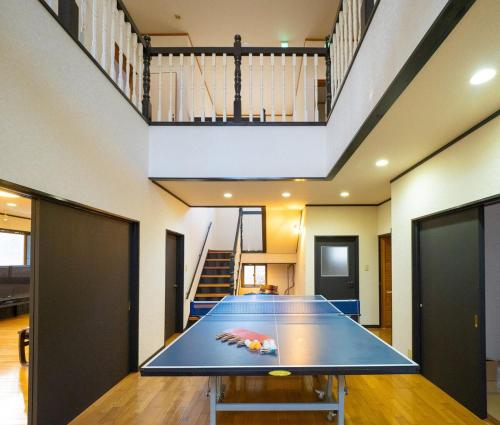 a ping pong table in a room with a staircase at venasuｵｰﾍﾞﾙｼﾞｰﾇ館 卓球カラオケ シアター 石風呂 ドッグラン BBQ in Nasushiobara