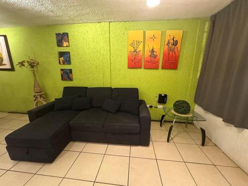 a living room with a couch and a green wall at House by American Consulate Cd in Manuel F. Martínez