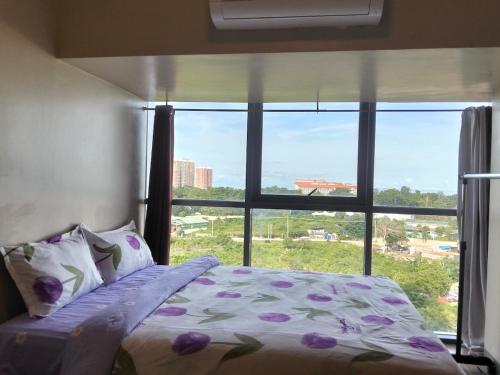 a bedroom with a bed and a large window at 3 BRooms 3 Baths Cozy Condo, One Manchester Place in Lapu Lapu City