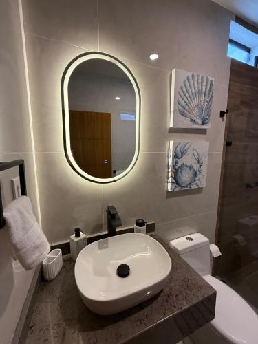 a bathroom with a sink and a mirror and a toilet at Casa al Mare in Mazatlán