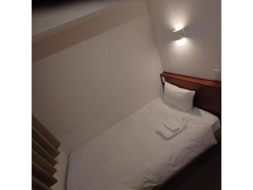 małe łóżko z dwoma białymi ręcznikami w obiekcie Smile Hotel Namba - Vacation STAY 67913v w Osace