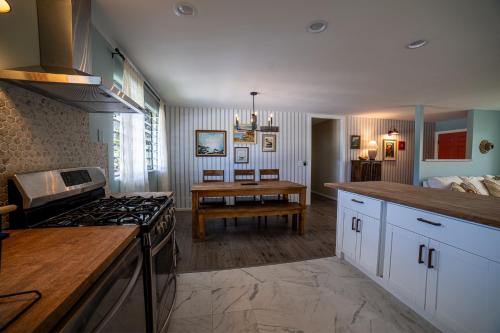 a kitchen with a stove and a table in it at Stylized Captain's House in Captain Cook