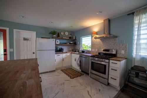 a kitchen with a white refrigerator and a stove at Stylized Captain's House in Captain Cook