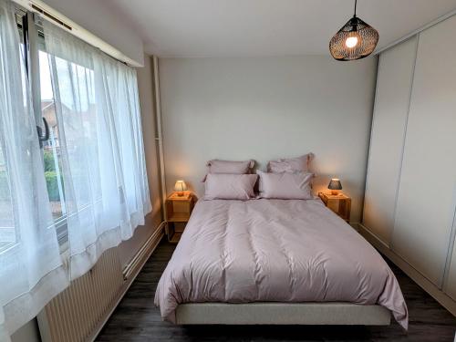 une chambre avec un lit et une grande fenêtre dans l'établissement Appartement accueillant au cœur de Luxeuil-les-Bains proche thermes - FR-1-583-510, à Luxeuil-les-Bains