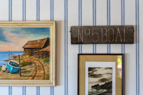 two pictures on a wall with a no boat sign at Stylized Captain's House in Captain Cook