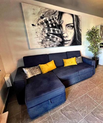 a blue couch with yellow pillows in a living room at Apartment near consulate D4 in Manuel F. Martínez