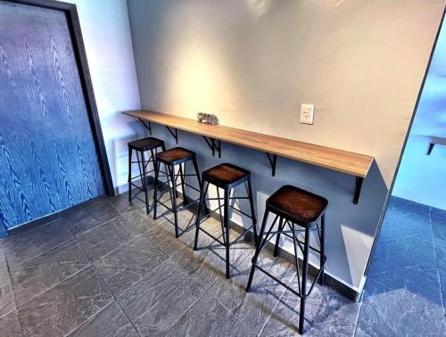 a bar with stools in a room with a wall at Apartment near consulate D4 in Manuel F. Martínez